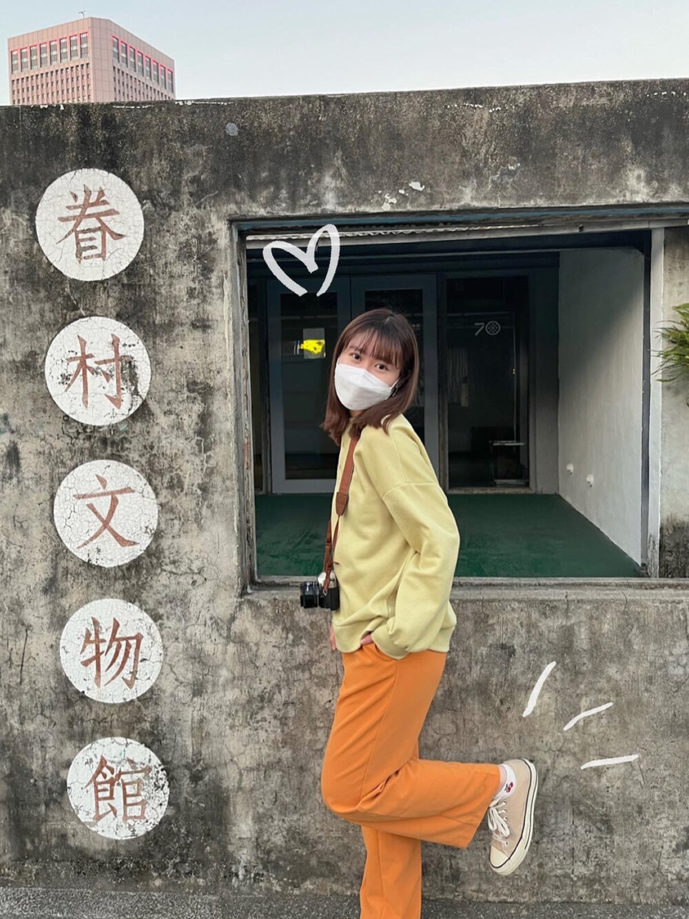 オレンジ系のスラックス、ベージュ系のシューズ、グリーン系のTシャツ/カットソーを着用したレディースの冬コーディネートの4枚目の写真