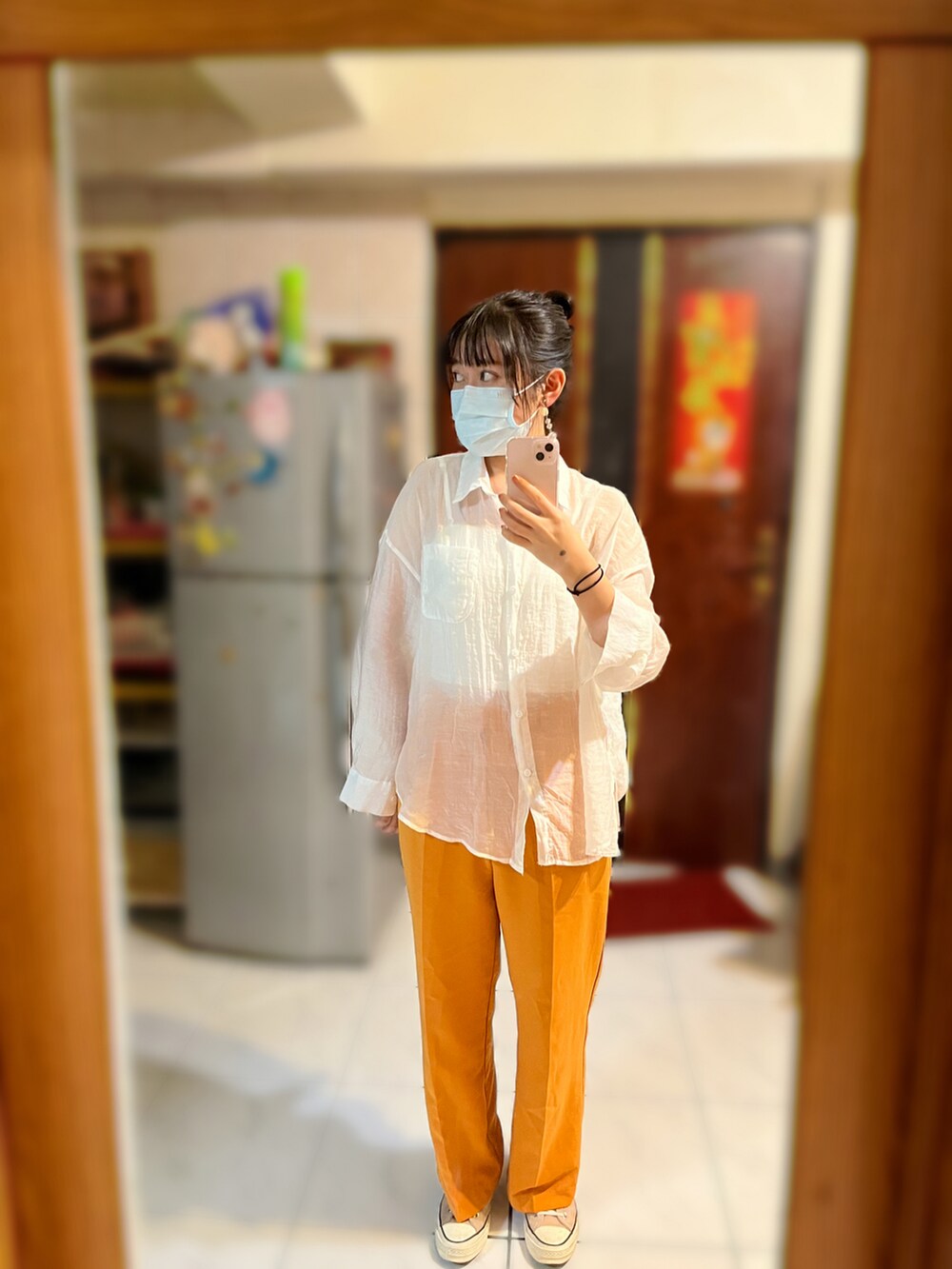 オレンジ系のスラックス、ホワイト系のシャツ/ブラウス、ホワイト系のチューブトップを着用したレディースの秋コーディネートの2枚目の写真