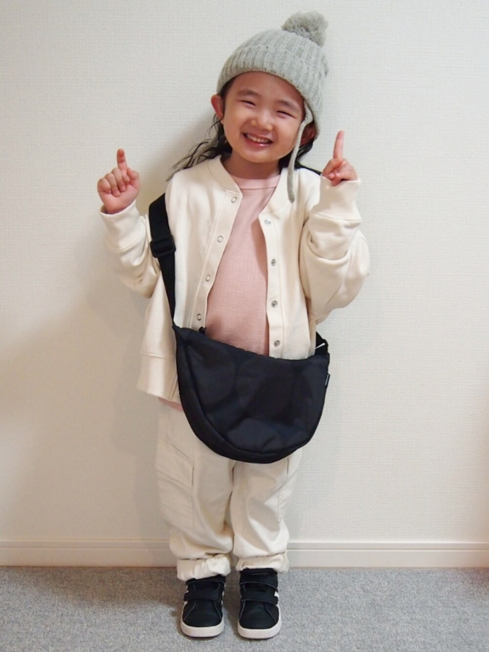 ホワイト系のノーカラージャケット、ピンク系のTシャツ/カットソー、ホワイト系のカーゴパンツを着用したキッズの冬コーディネートの3枚目の写真