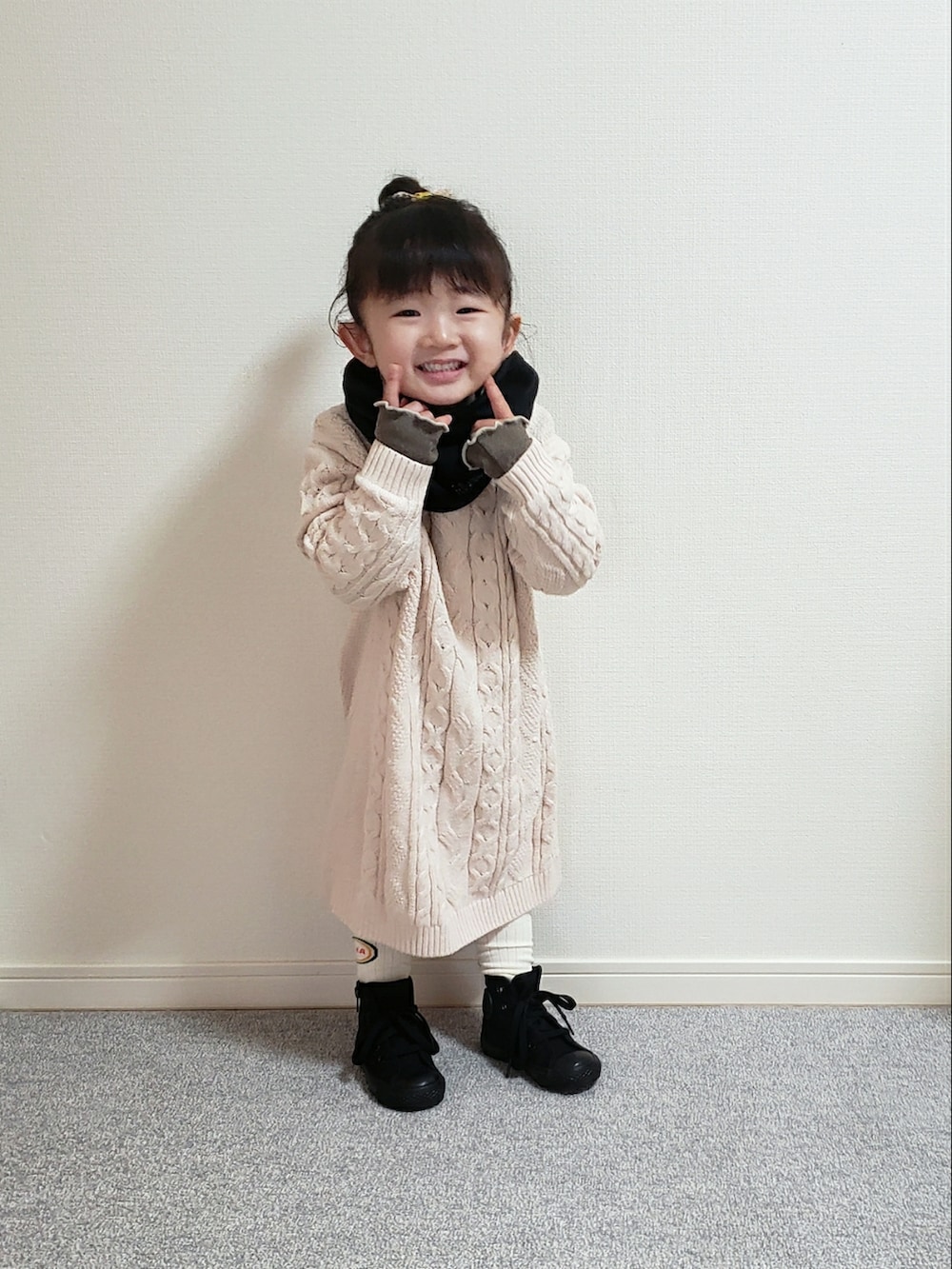 ホワイト系のワンピース、ブラウン系のTシャツ/カットソー、ブラック系のスニーカーを着用したキッズの冬コーディネートの2枚目の写真