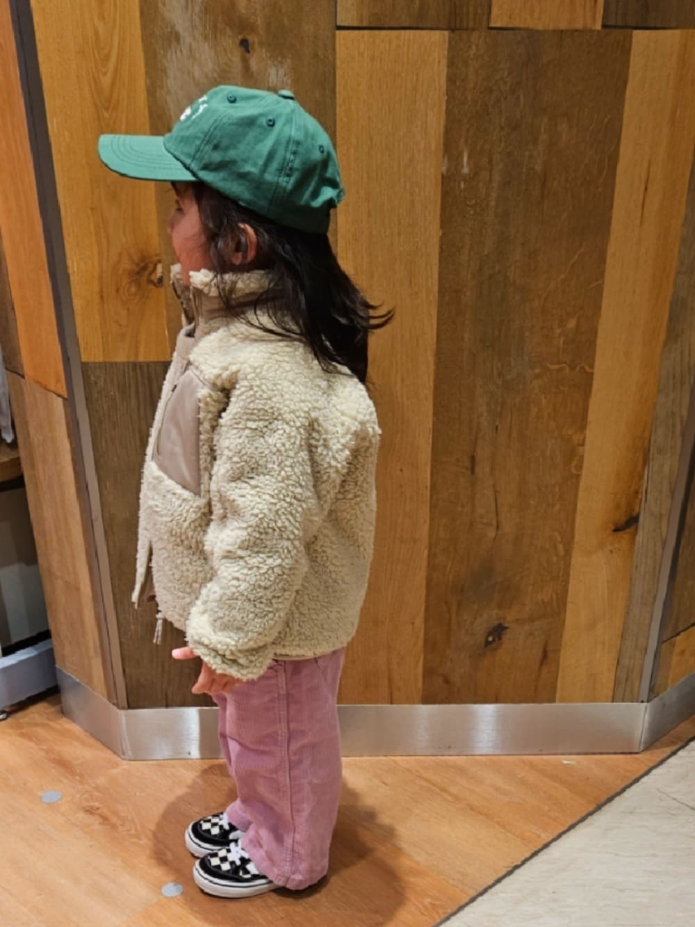 ベージュ系のジャケット/アウター、ホワイト系のニット/セーター、ブラウン系のTシャツ/カットソーを着用したキッズの冬コーディネートの4枚目の写真