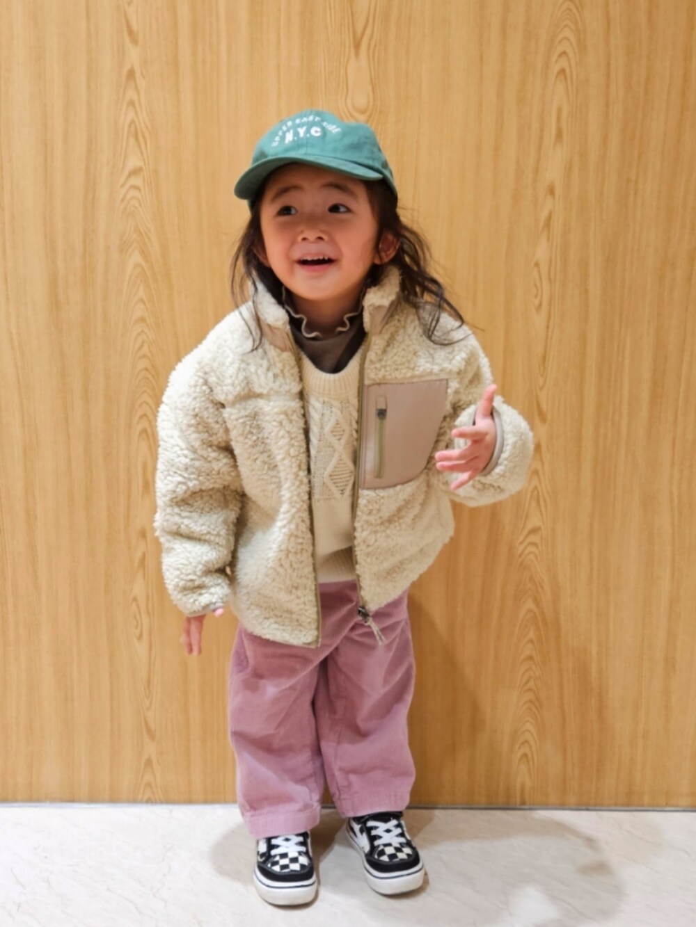 ベージュ系のジャケット/アウター、ホワイト系のニット/セーター、ブラウン系のTシャツ/カットソーを着用したキッズの冬コーディネートの2枚目の写真