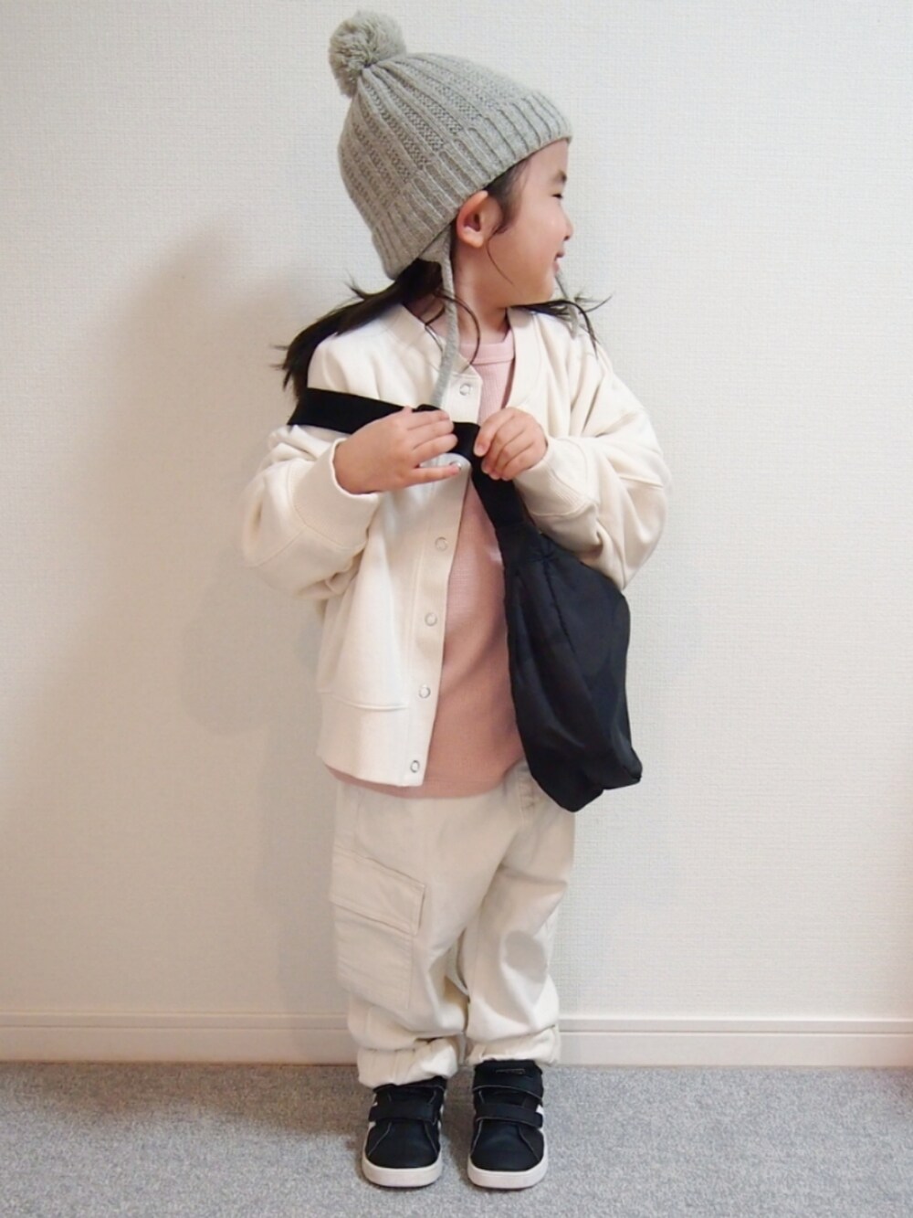 ホワイト系のノーカラージャケット、ピンク系のTシャツ/カットソー、ホワイト系のカーゴパンツを着用したキッズの冬コーディネートの2枚目の写真