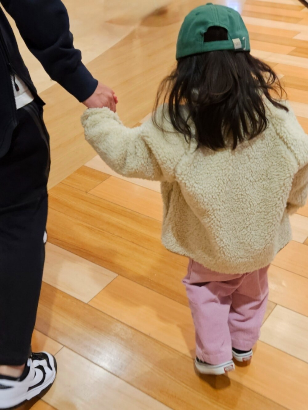 ベージュ系のジャケット/アウター、ホワイト系のニット/セーター、ブラウン系のTシャツ/カットソーを着用したキッズの冬コーディネートの3枚目の写真