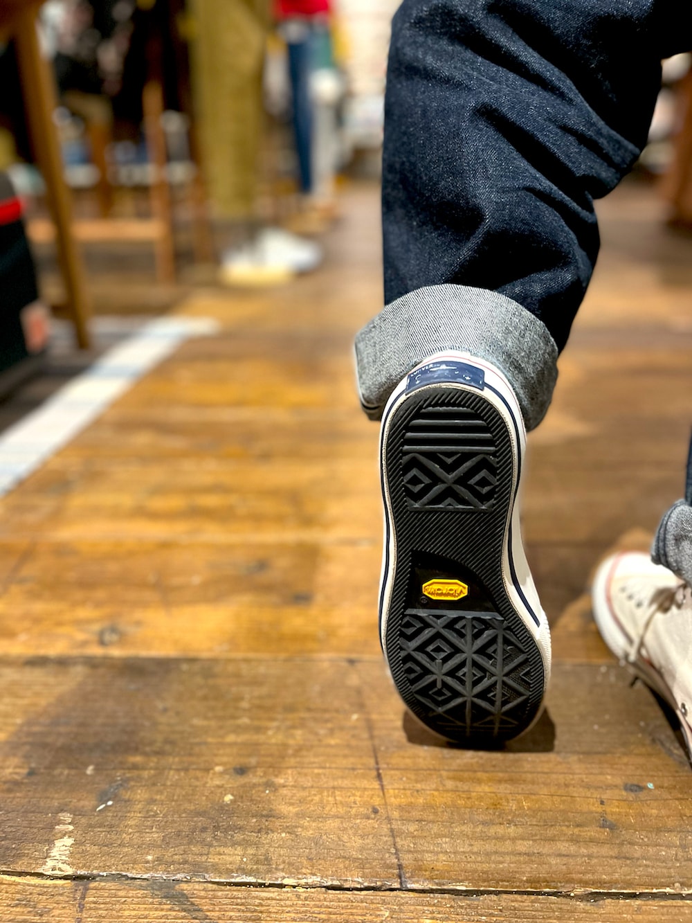 ブラック系のスタジャン、ホワイト系のニット/セーター、ブルー系のデニムパンツを着用したメンズの秋コーディネートの2枚目の写真