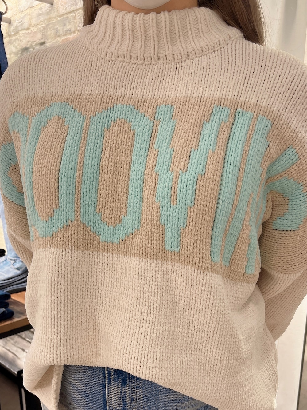 ホワイト系のニット/セーター、ブルー系のデニムスカート、ホワイト系のハンドバッグを着用したレディースの冬コーディネートの3枚目の写真