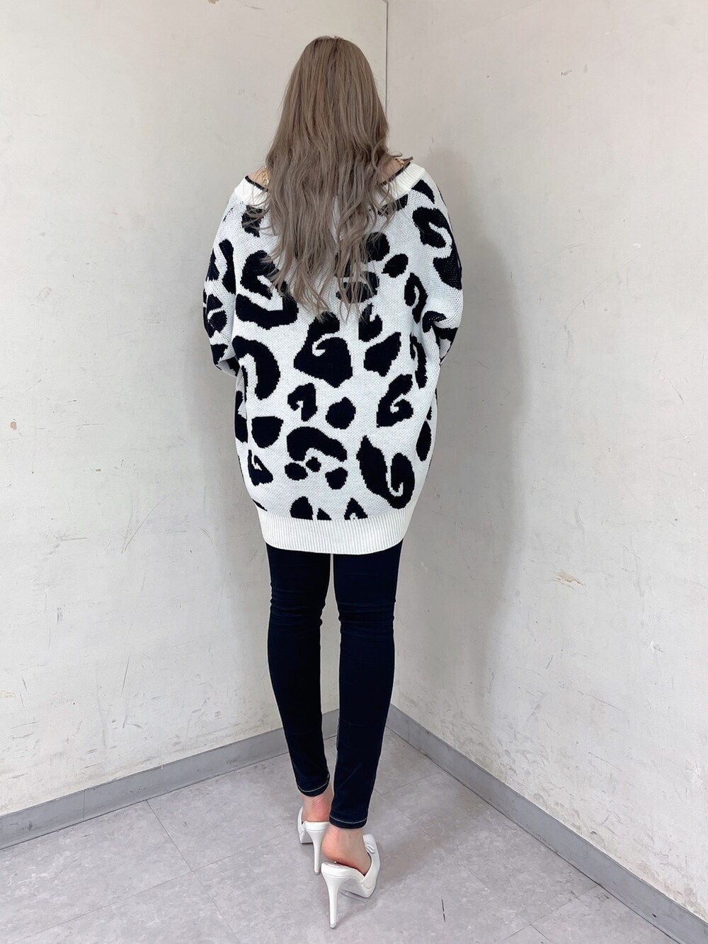 ホワイト系のカーディガン/ボレロ、ブラック系のキャミソール、ブラック系のデニムパンツを着用したレディースの春コーディネートの3枚目の写真