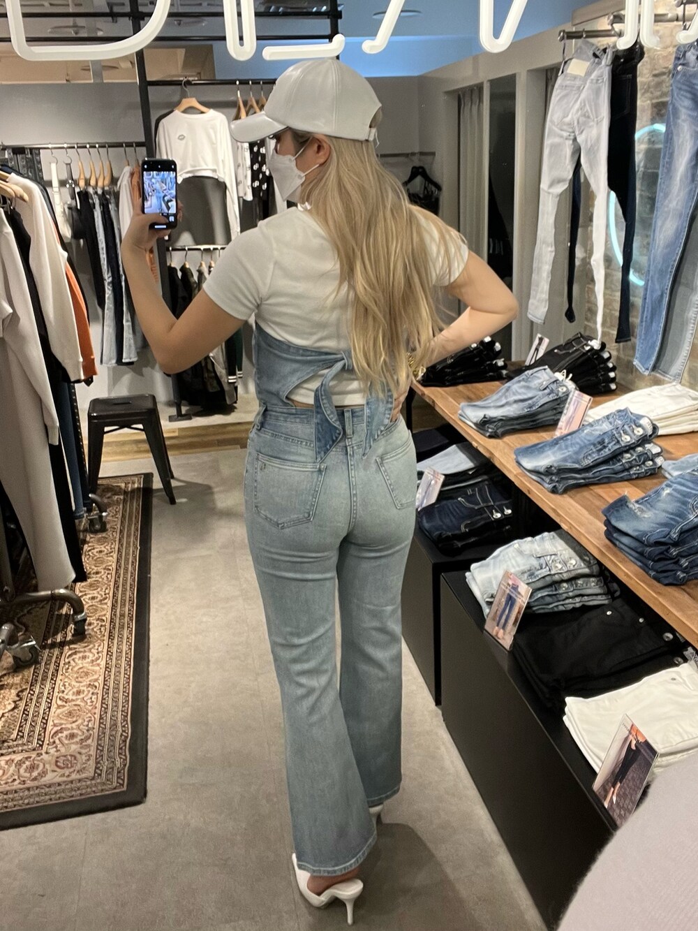 ブルー系のサロペット/オーバーオール、ピンク系のカーディガン/ボレロ、ホワイト系のTシャツ/カットソーを着用したレディースの春コーディネートの3枚目の写真