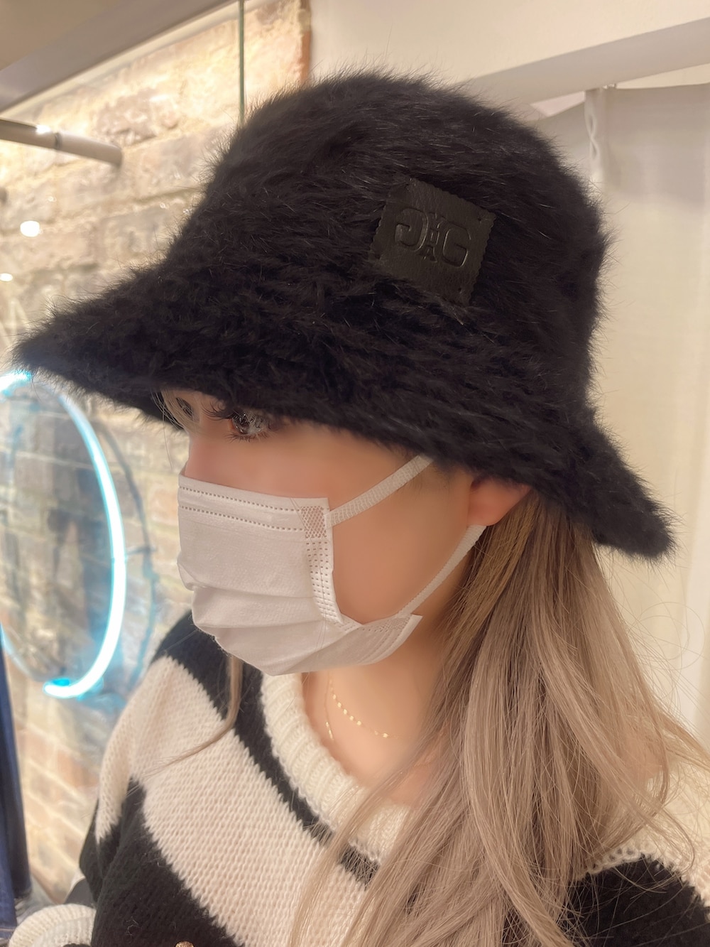 ブルー系のデニムパンツ、ブラック系のニット/セーター、ブラック系のハンドバッグを着用したレディースの秋コーディネートの5枚目の写真