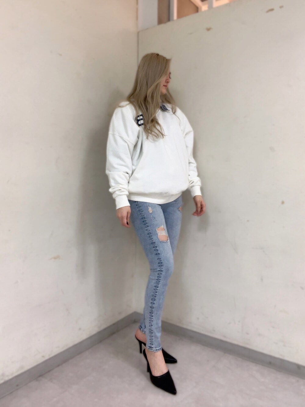 ホワイト系のスウェット、ホワイト系のシャツ/ブラウス、ブルー系のデニムパンツを着用したレディースの冬コーディネートの2枚目の写真