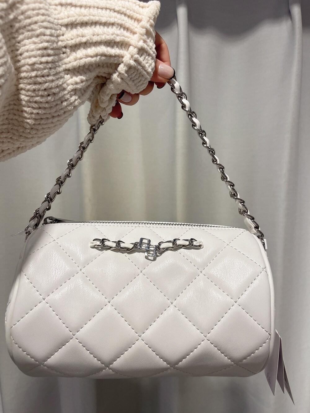 ホワイト系のニット/セーター、ブルー系のデニムスカート、ホワイト系のハンドバッグを着用したレディースの冬コーディネートの5枚目の写真