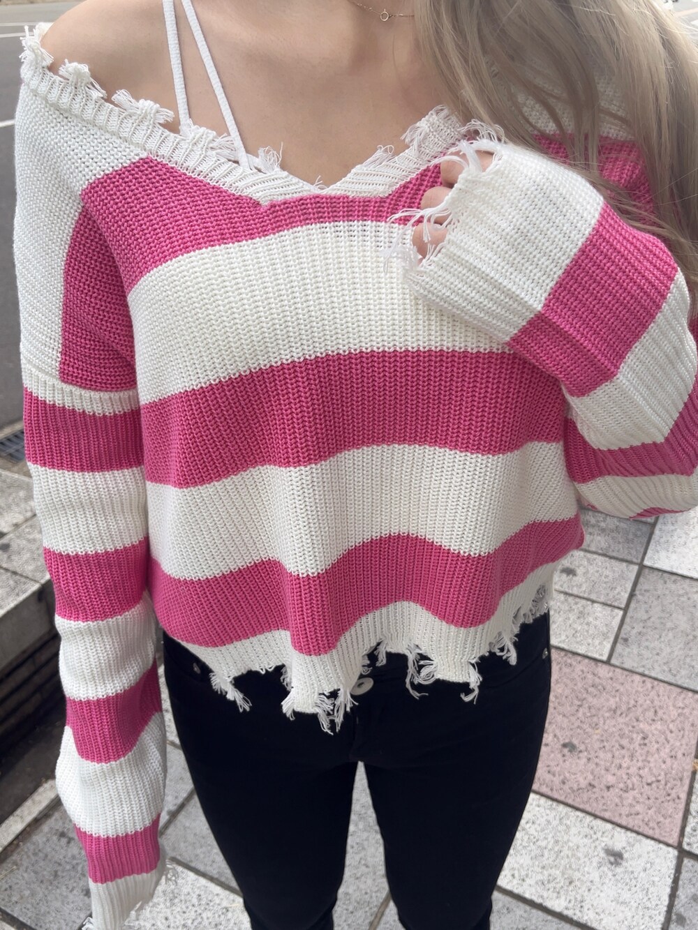 ホワイト系のスニーカー、ブラック系のデニムパンツ、ホワイト系のキャミソールを着用したレディースの冬コーディネートの3枚目の写真