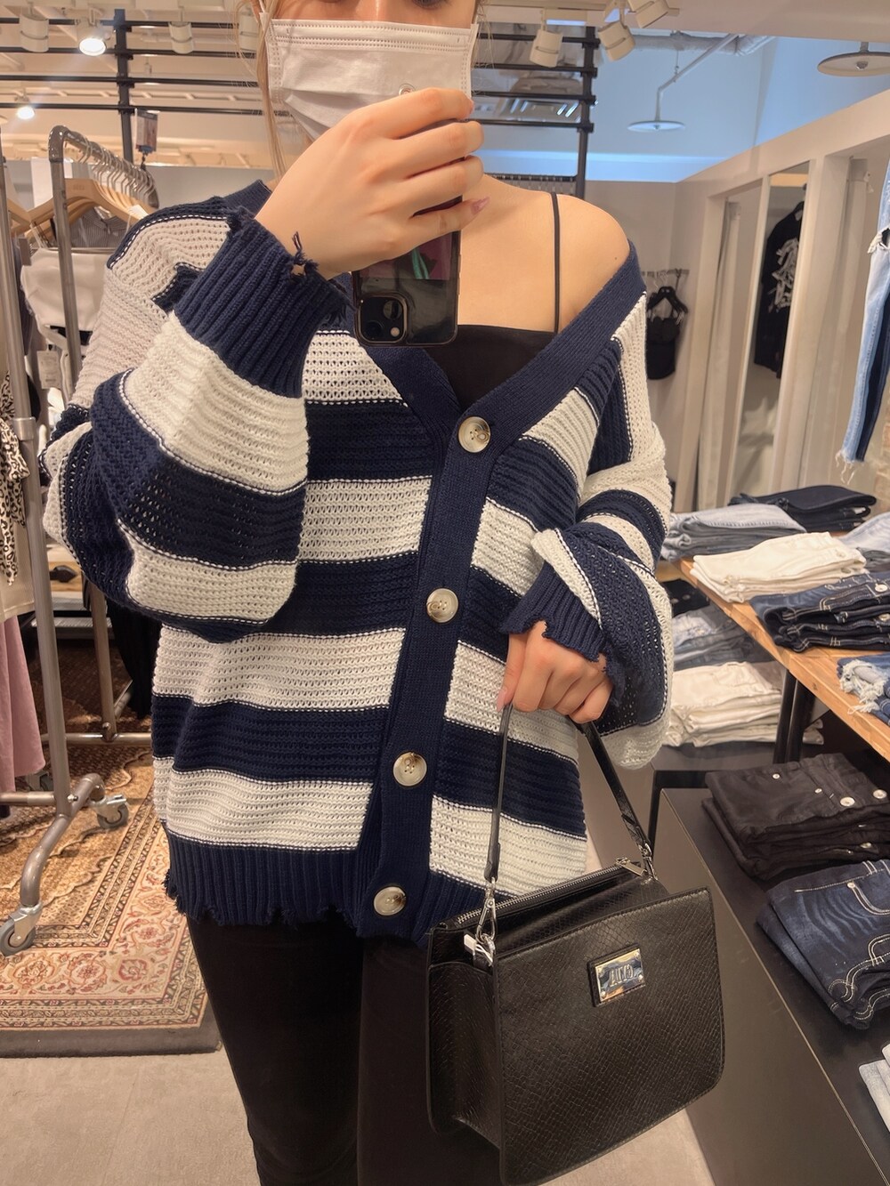 ブラック系のタンクトップ、ブルー系のカーディガン/ボレロ、ブラック系のハンドバッグを着用したレディースの夏コーディネートの2枚目の写真