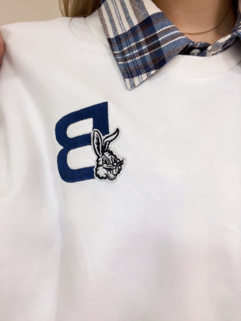 ホワイト系のスウェット、ホワイト系のシャツ/ブラウス、ブルー系のデニムパンツを着用したレディースの冬コーディネートの3枚目の写真