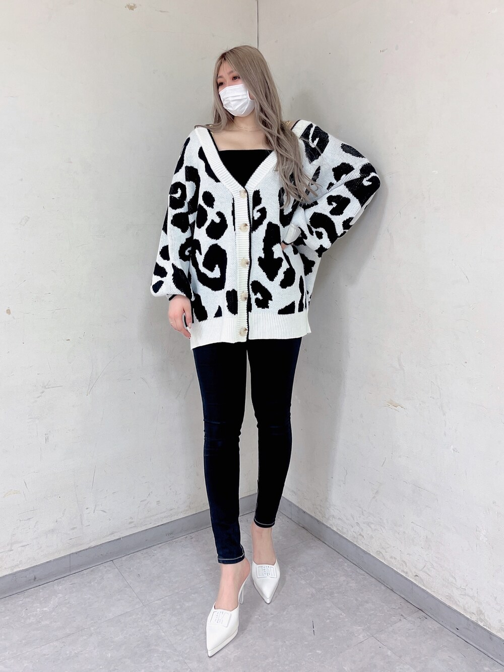 ホワイト系のカーディガン/ボレロ、ブラック系のキャミソール、ブラック系のデニムパンツを着用したレディースの春コーディネートの2枚目の写真