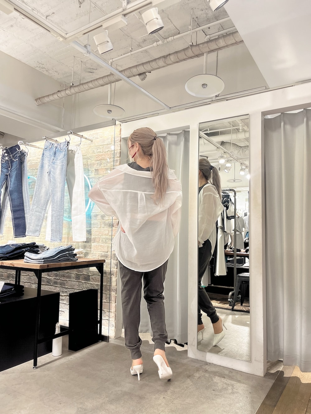 グレー系のタンクトップ、ホワイト系のシャツ/ブラウス、グレー系のスウェットパンツを着用したレディースの春コーディネートの2枚目の写真