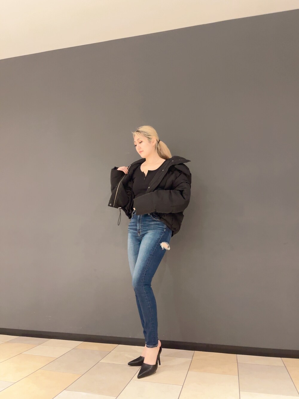 ブルー系のデニムパンツ、ブラック系のパンプス、ブラック系のTシャツ/カットソーを着用したレディースの秋コーディネートの4枚目の写真