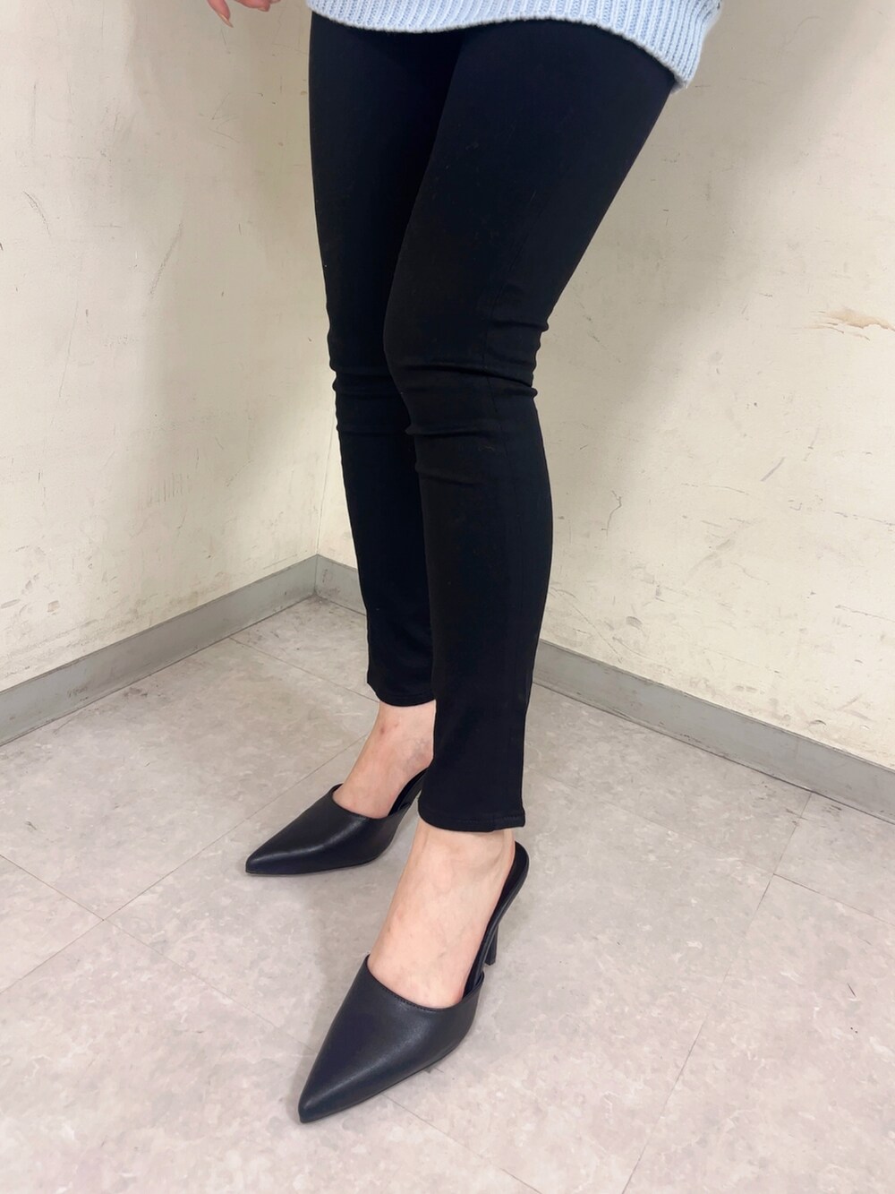 ブルー系のニット/セーター、ブラック系のデニムパンツ、ブラック系のパンプスを着用したレディースの冬コーディネートの3枚目の写真
