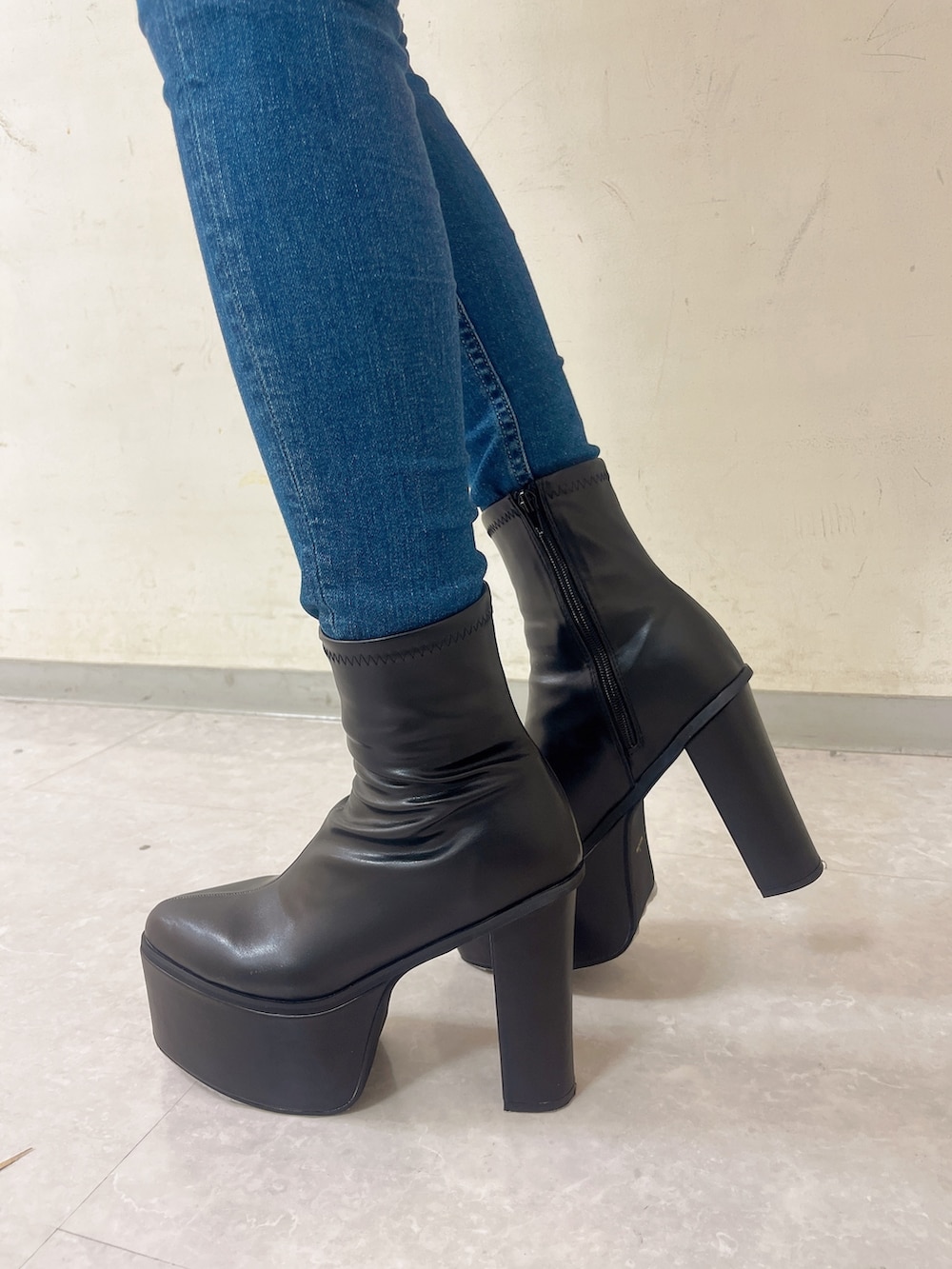 ブラック系のニット/セーター、ブルー系のデニムパンツ、ブラック系のブーツを着用したレディースの秋コーディネートの4枚目の写真