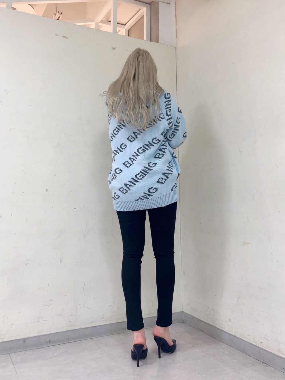 ブルー系のニット/セーター、ブラック系のデニムパンツ、ブラック系のパンプスを着用したレディースの冬コーディネートの2枚目の写真