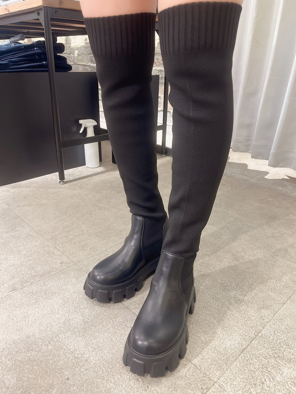 ブルー系のデニムパンツ、ブラック系のニット/セーター、ブラック系のハンドバッグを着用したレディースの秋コーディネートの6枚目の写真