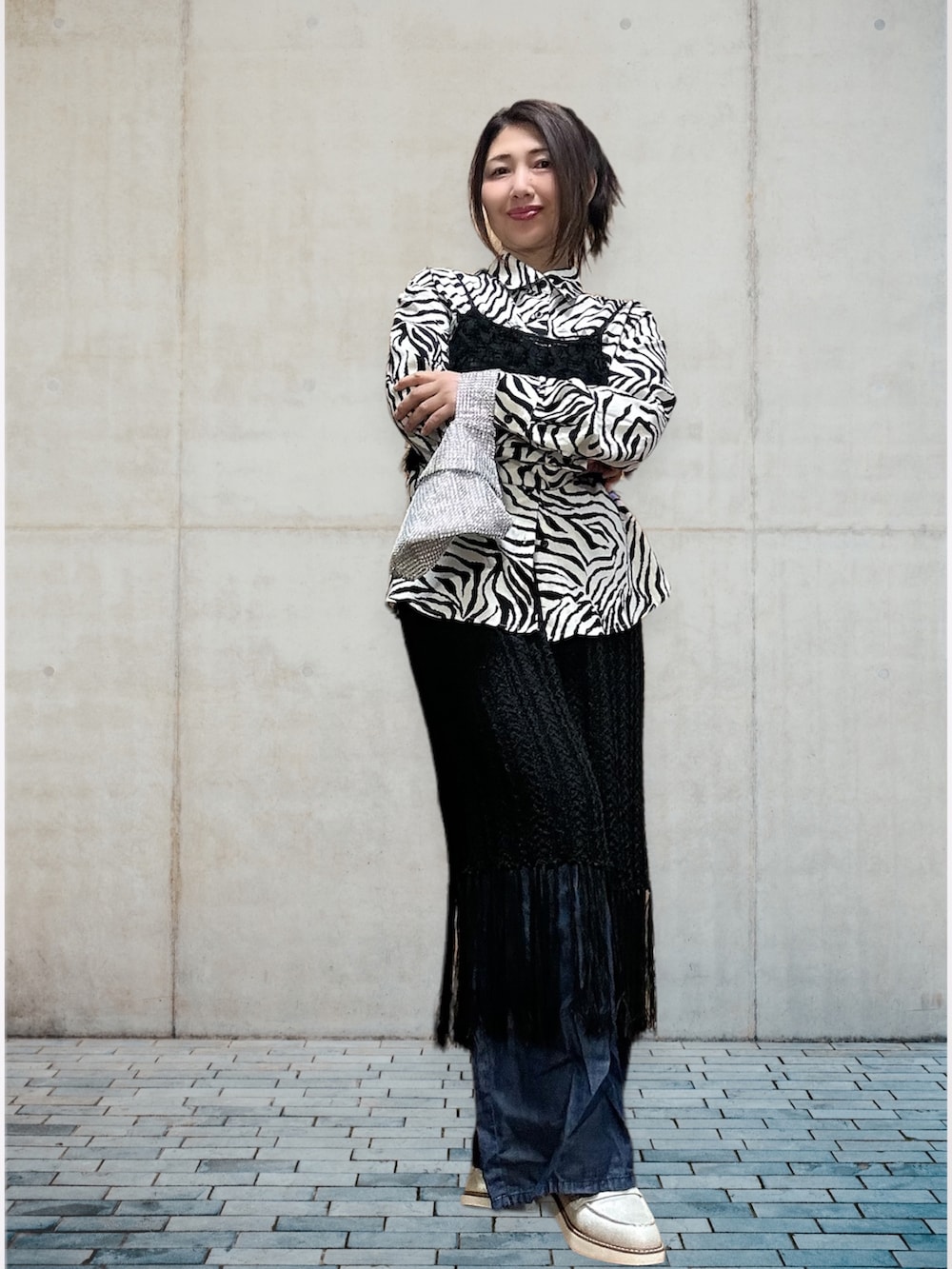 ブラック系のキャミソール、ブラック系のスカート、ブルー系のデニムパンツを着用したレディースの春コーディネートの4枚目の写真