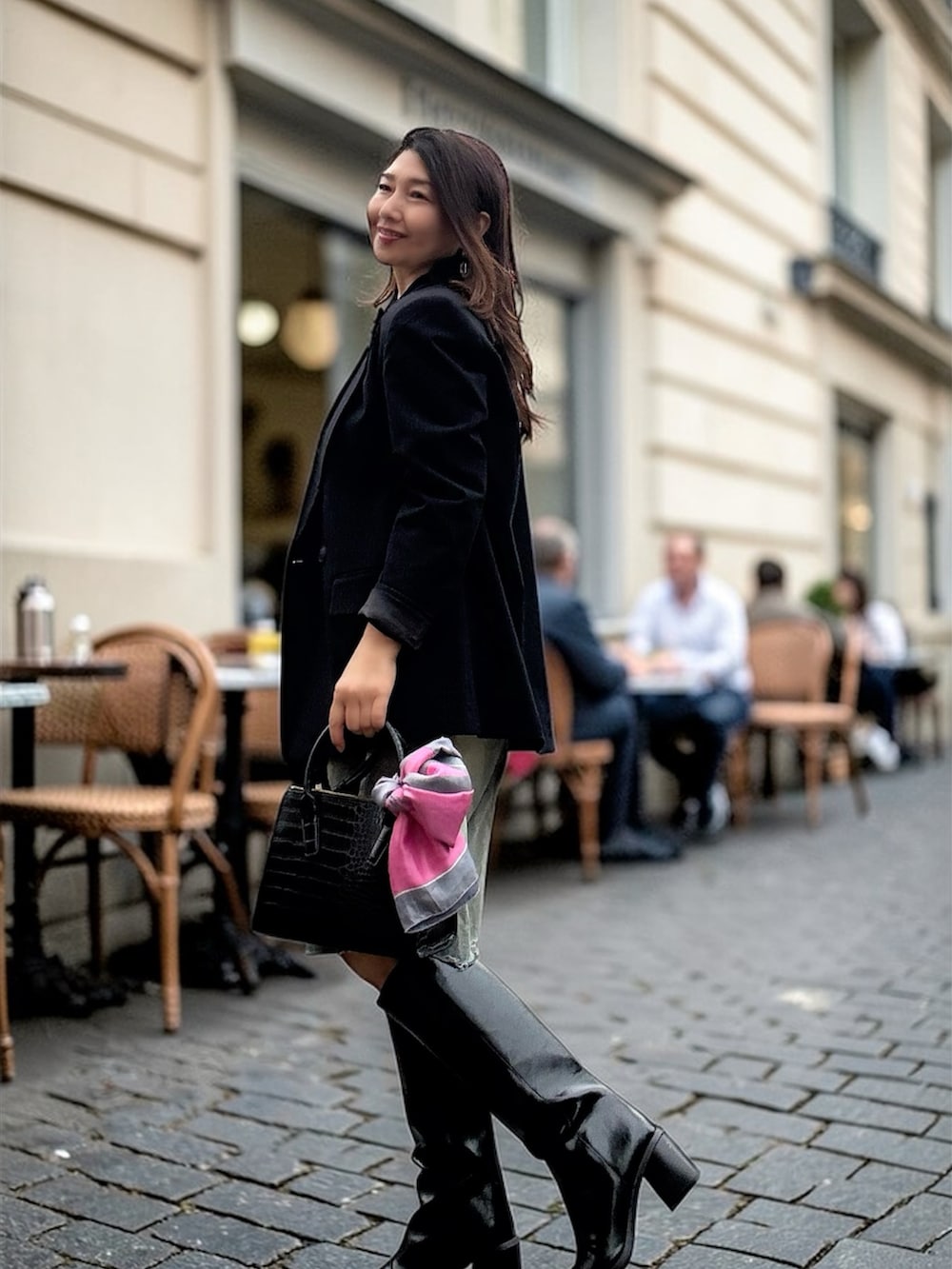 ブラック系のバッグ、ブラック系のブーツ、ブラック系のジャケット/アウターを着用したレディースの春コーディネートの2枚目の写真