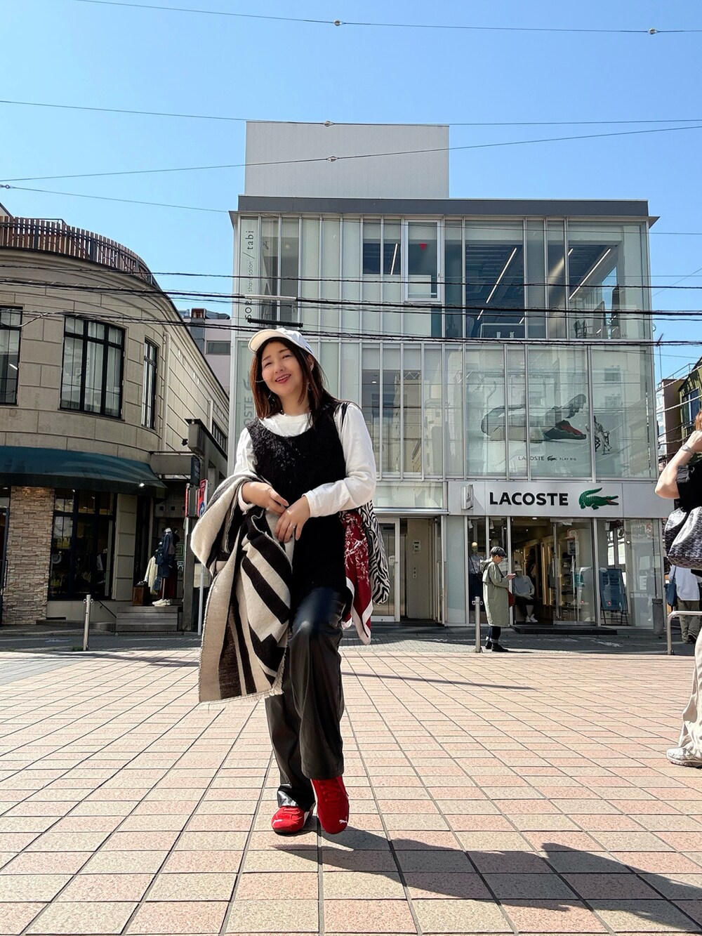 レッド系のスニーカー、ブラック系のTシャツ/カットソー、ホワイト系のTシャツ/カットソーを着用したレディースの春コーディネートの2枚目の写真