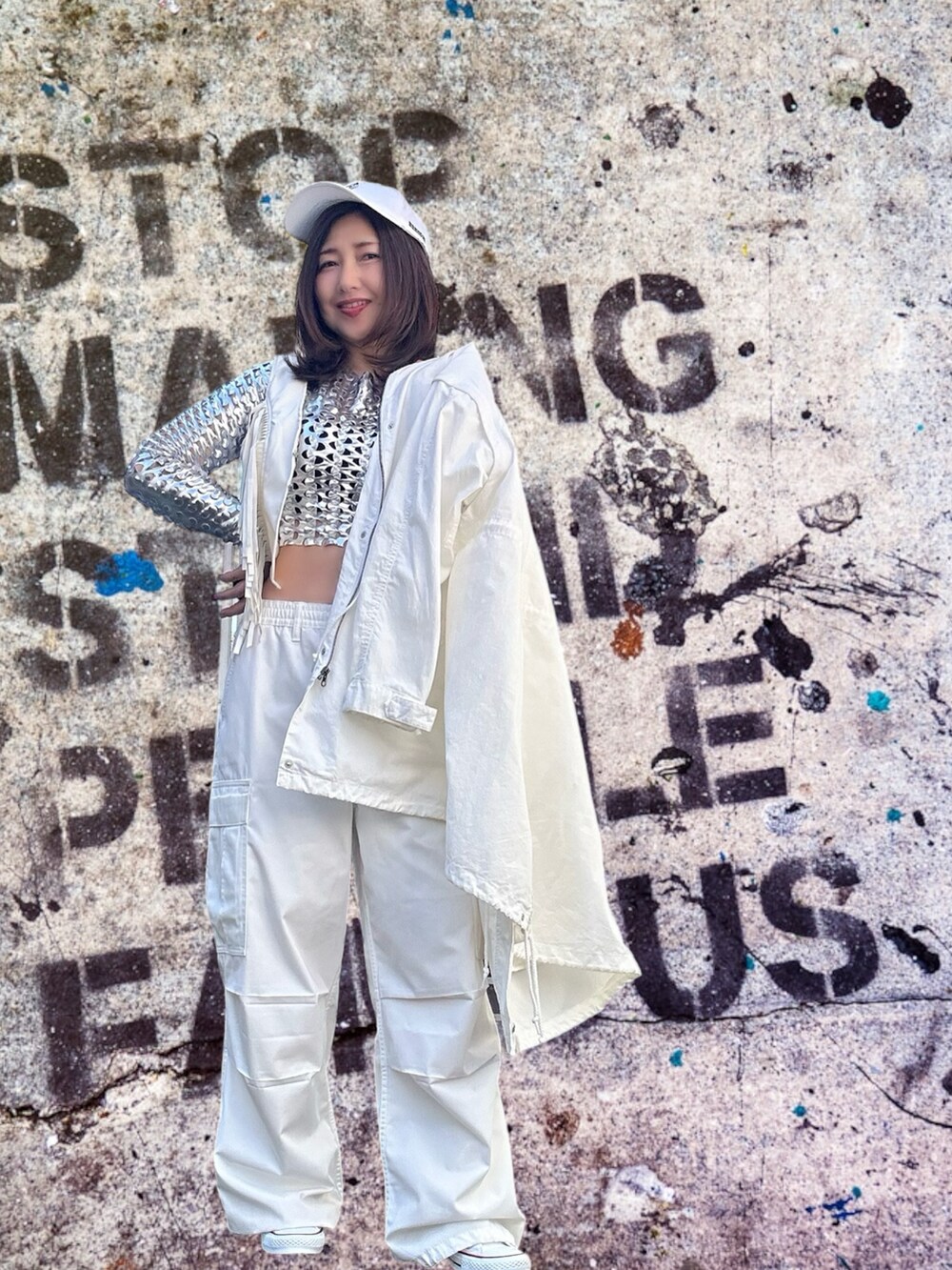 シルバー系のトップス、ホワイト系のベスト、ホワイト系のダウンベストを着用したレディースの春コーディネートの4枚目の写真