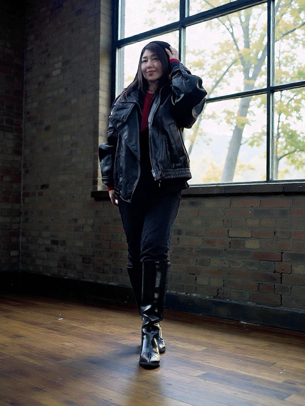 ブラック系のナイロンジャケット、レッド系のニット/セーター、ブラック系のベストを着用したレディースの冬コーディネートの3枚目の写真