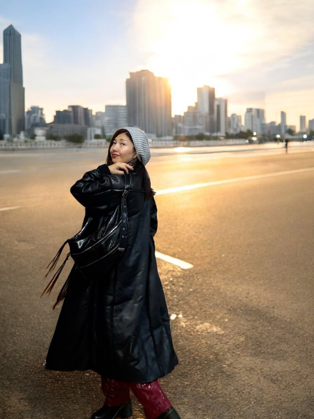 ブラック系のムートンコート、ブラック系のショルダーバッグ、ブラック系のブーツを着用したレディースの秋コーディネートの4枚目の写真