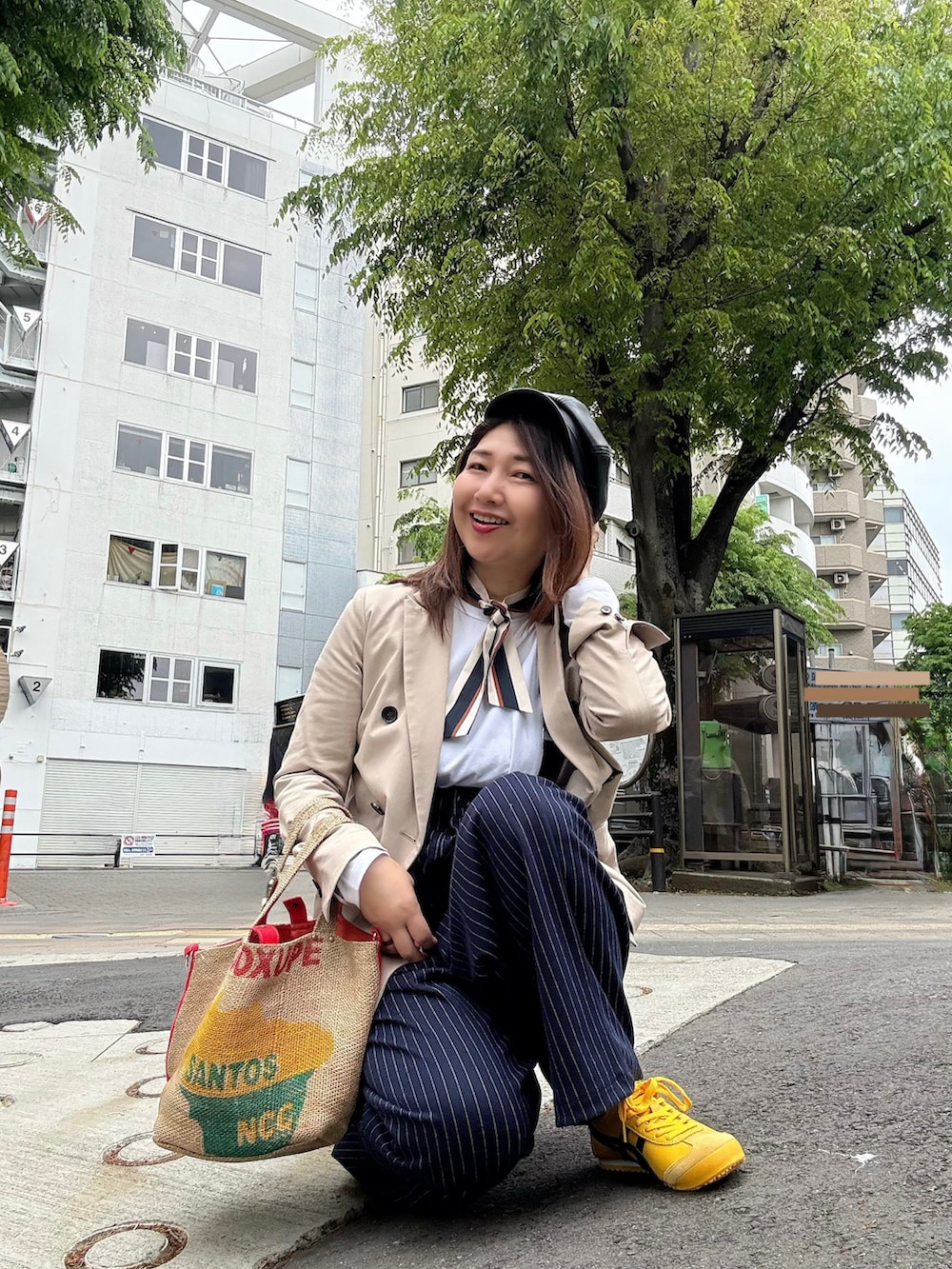 イエロー系のスニーカー、レッド系のトートバッグ、ベージュ系のテーラードジャケットを着用したレディースの春コーディネートの4枚目の写真