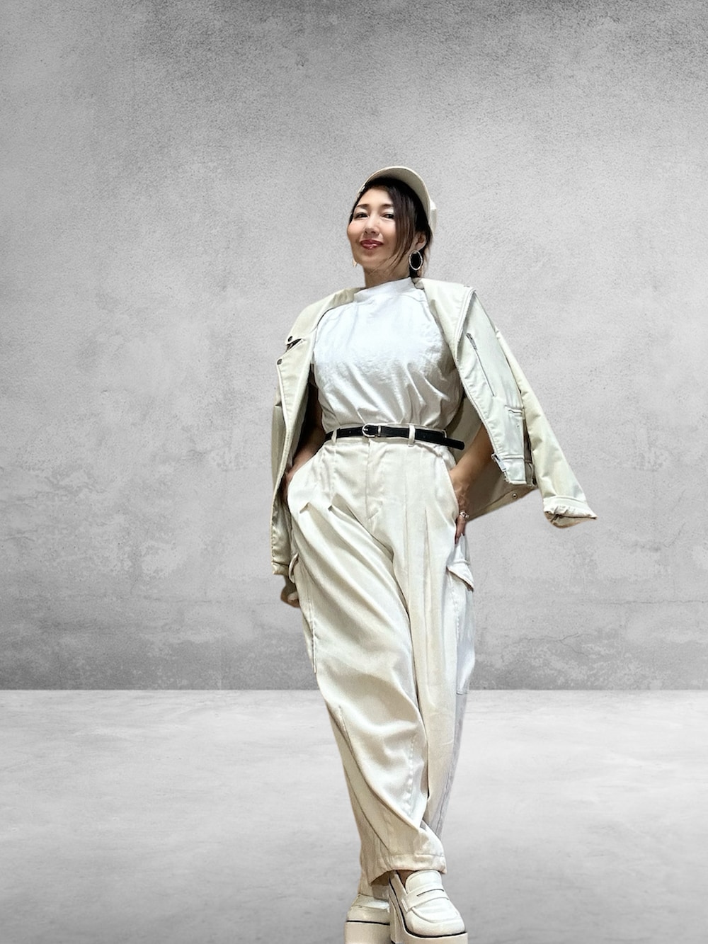 ホワイト系のカーゴパンツ、ホワイト系のTシャツ/カットソー、ホワイト系のライダースジャケットを着用したレディースの秋コーディネートの4枚目の写真