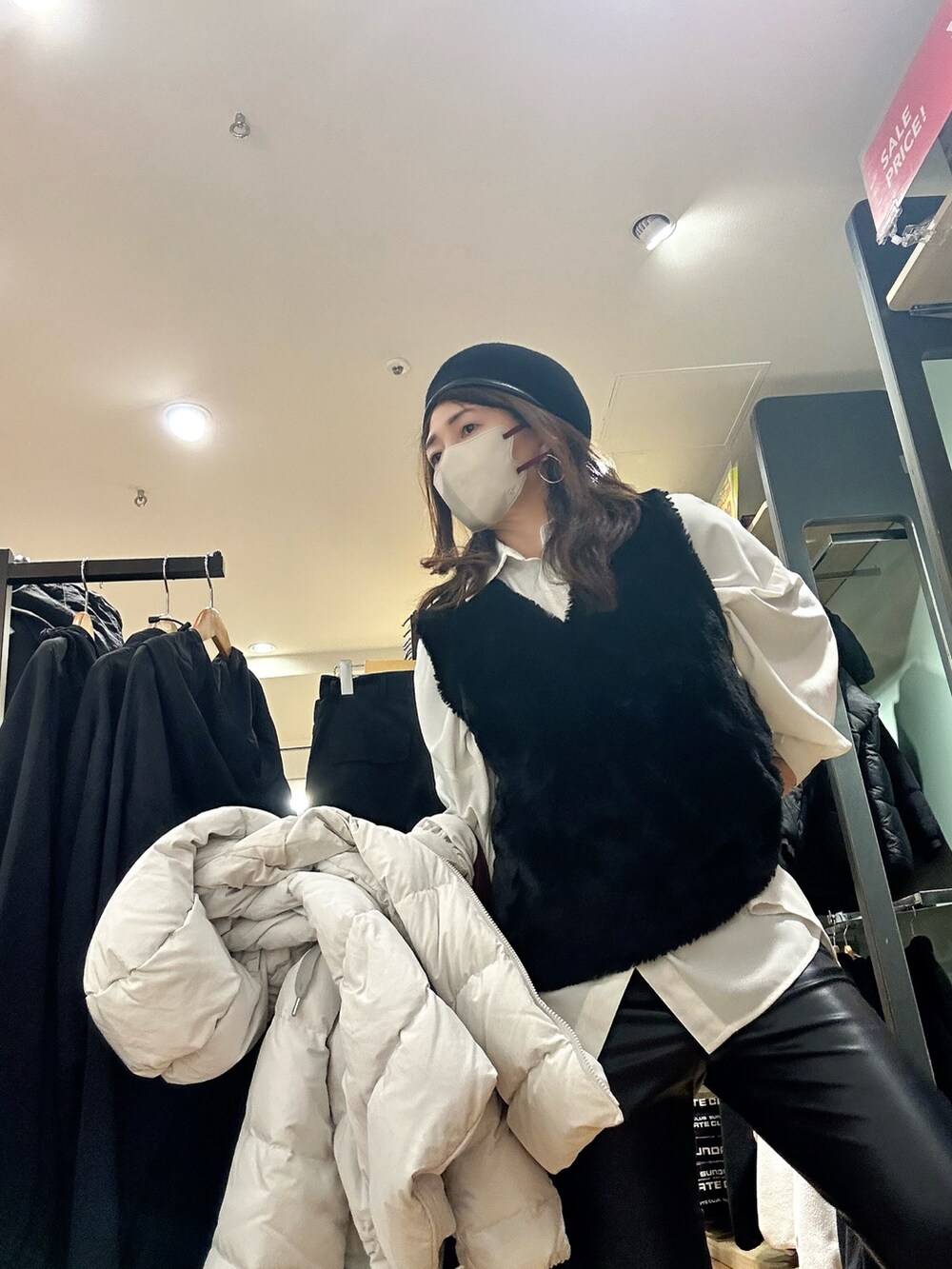グレー系のダウンジャケット/コート、ブラック系のパンツ、ブラック系のベストを着用したレディースの冬コーディネートの3枚目の写真