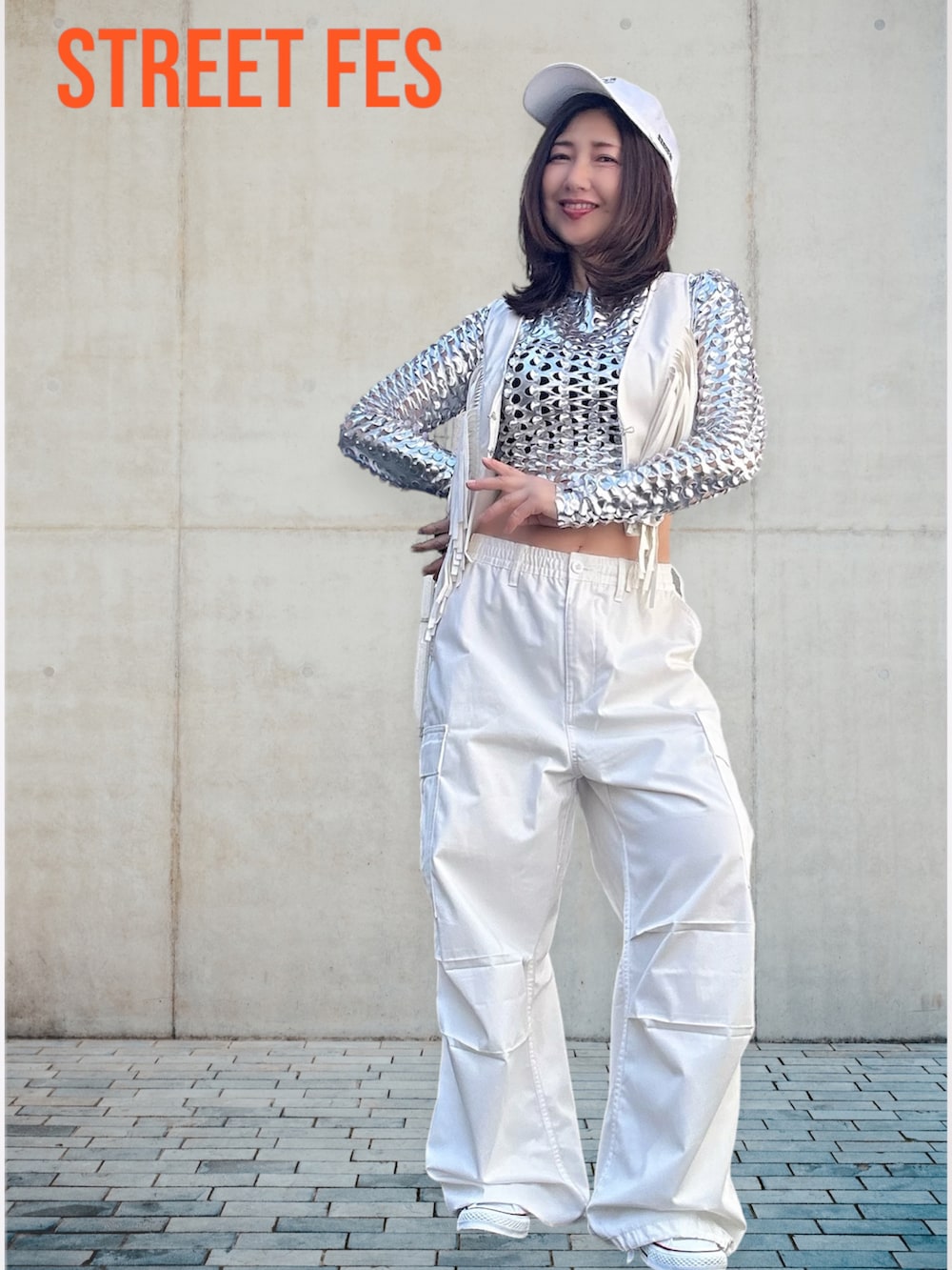 シルバー系のトップス、ホワイト系のベスト、ホワイト系のダウンベストを着用したレディースの春コーディネートの5枚目の写真