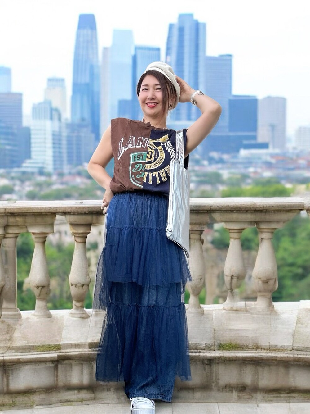 ホワイト系のスニーカー、グレー系のTシャツ/カットソー、ブルー系のデニムパンツを着用したレディースの秋コーディネートの4枚目の写真