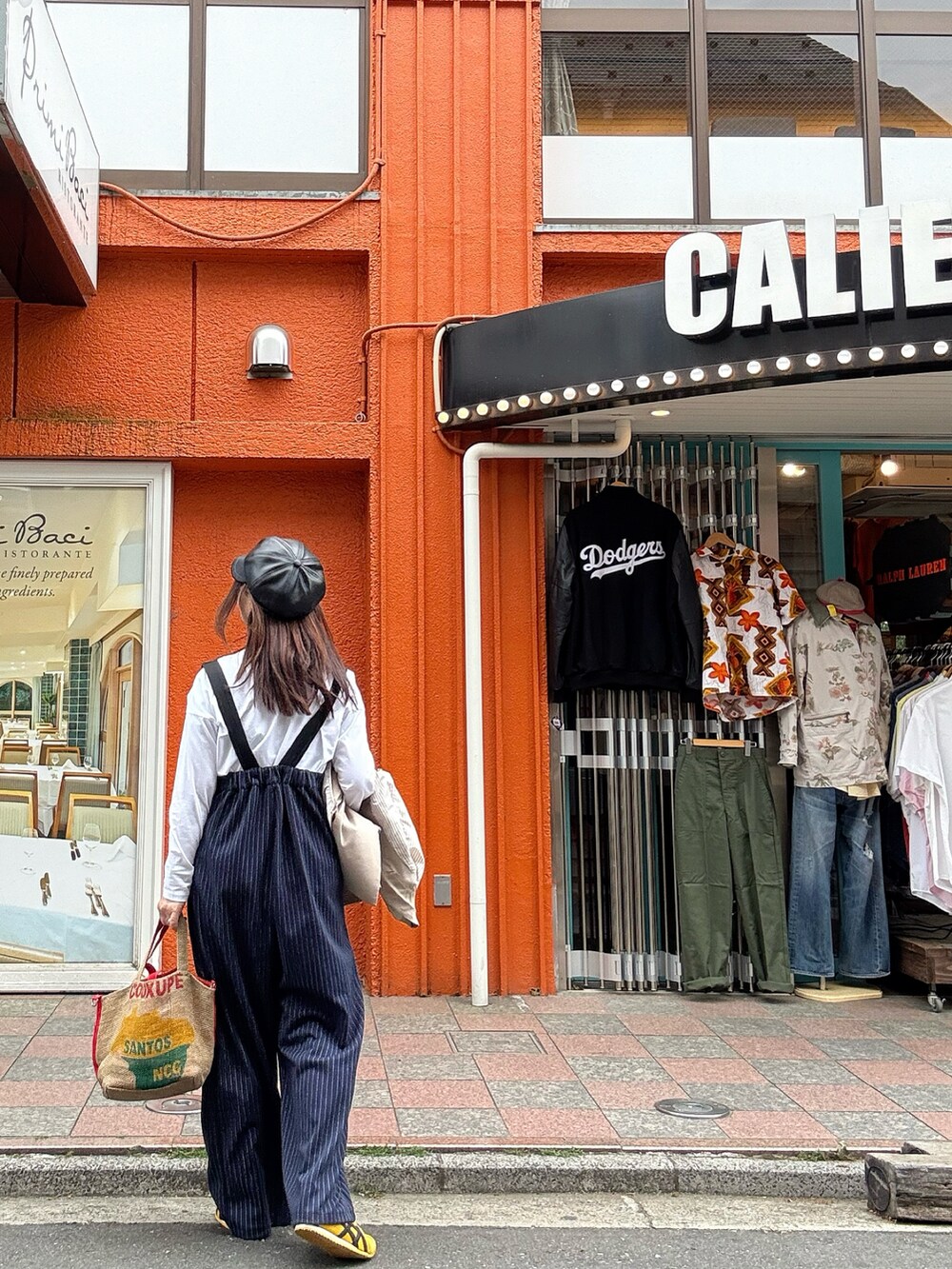 イエロー系のスニーカー、レッド系のトートバッグ、ベージュ系のテーラードジャケットを着用したレディースの春コーディネートの2枚目の写真