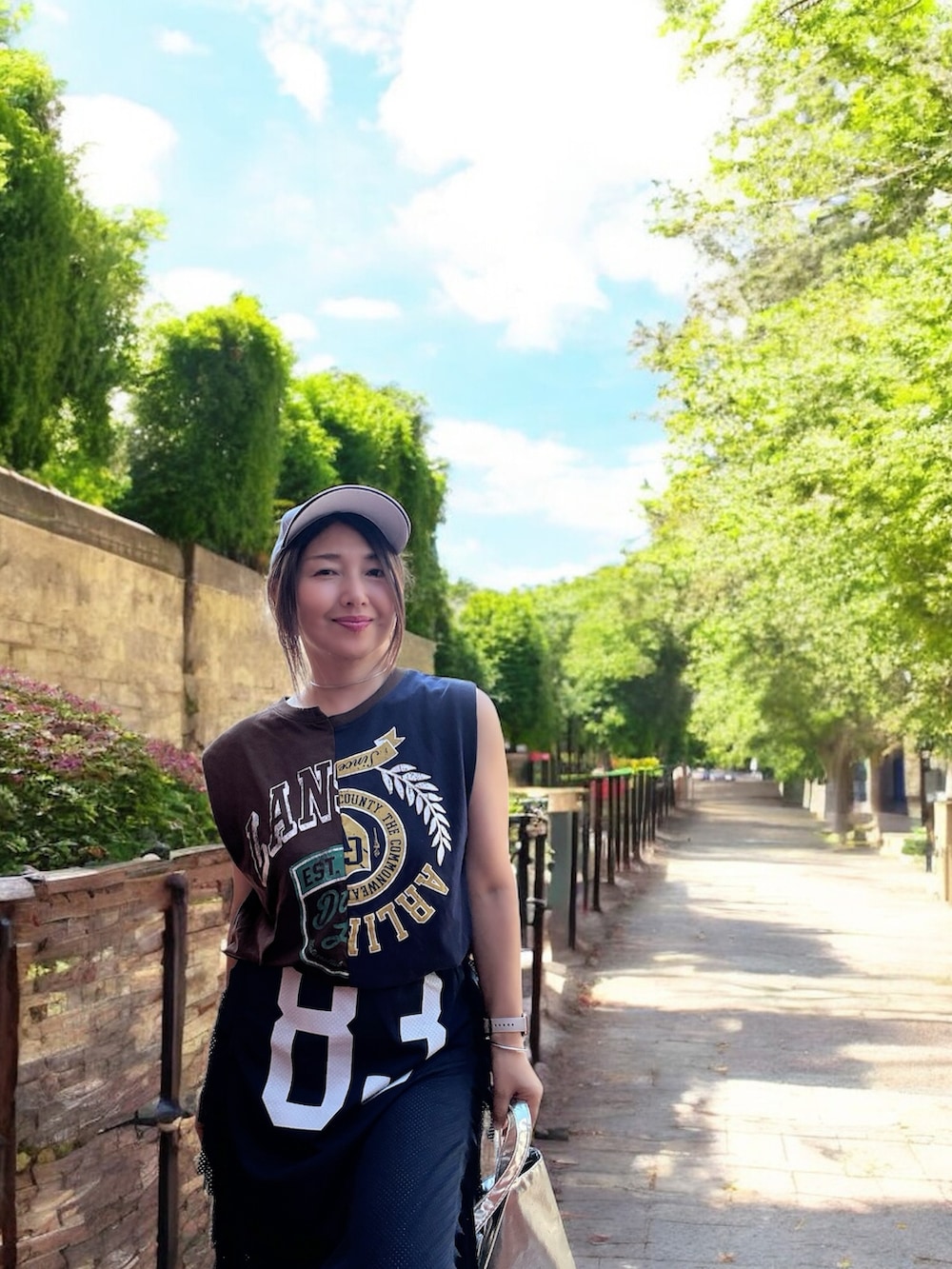 ブルー系のスカート、グレー系のTシャツ/カットソー、ホワイト系のサンダルを着用したレディースの夏コーディネートの2枚目の写真