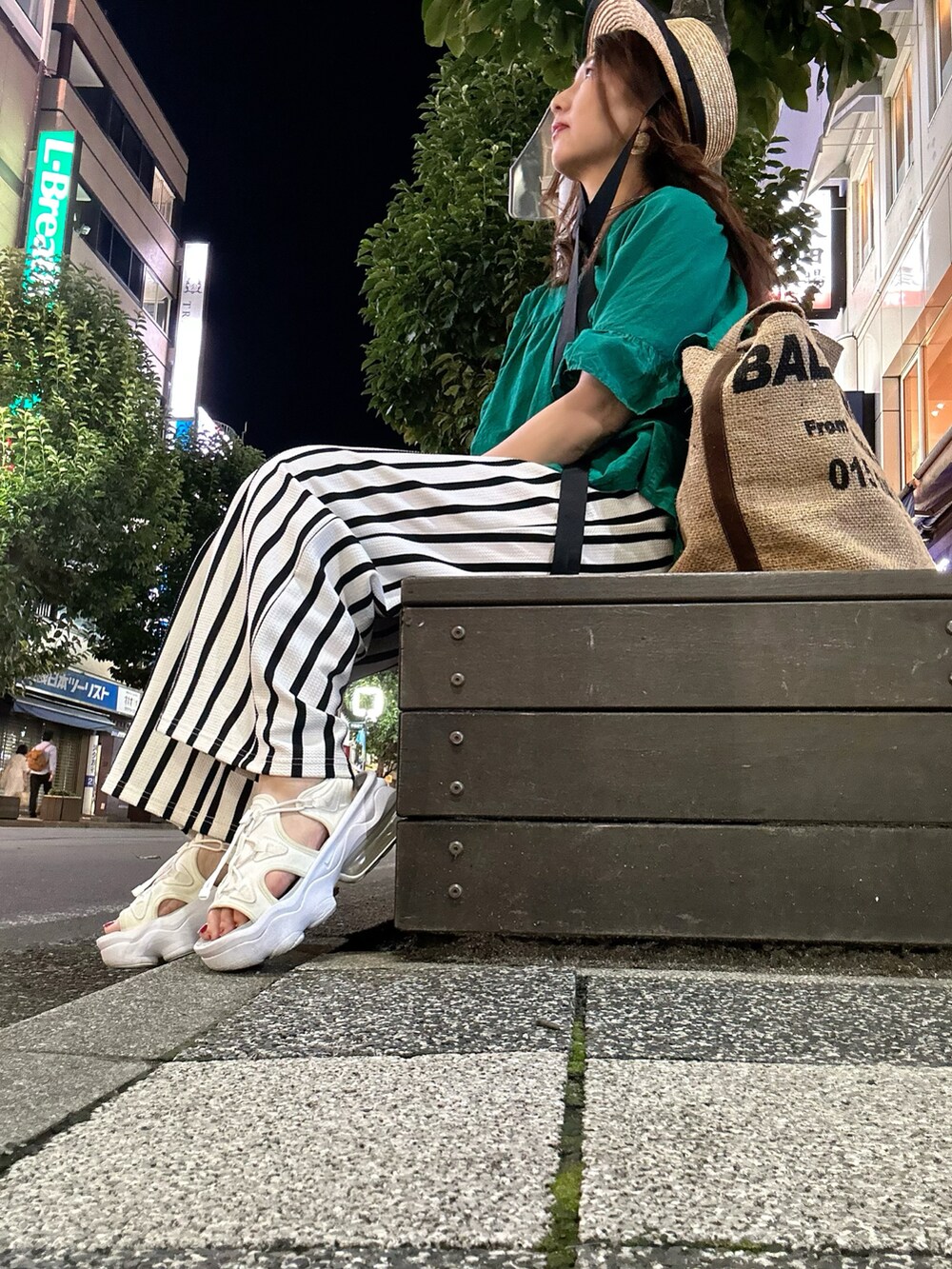 グリーン系のシャツ/ブラウス、ホワイト系のその他パンツ、ベージュ系のトートバッグを着用したレディースの夏コーディネートの2枚目の写真