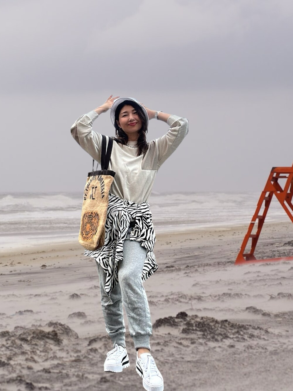 ホワイト系のスニーカー、ベージュ系のトートバッグ、ベージュ系のトップスを着用したレディースの春コーディネートの5枚目の写真