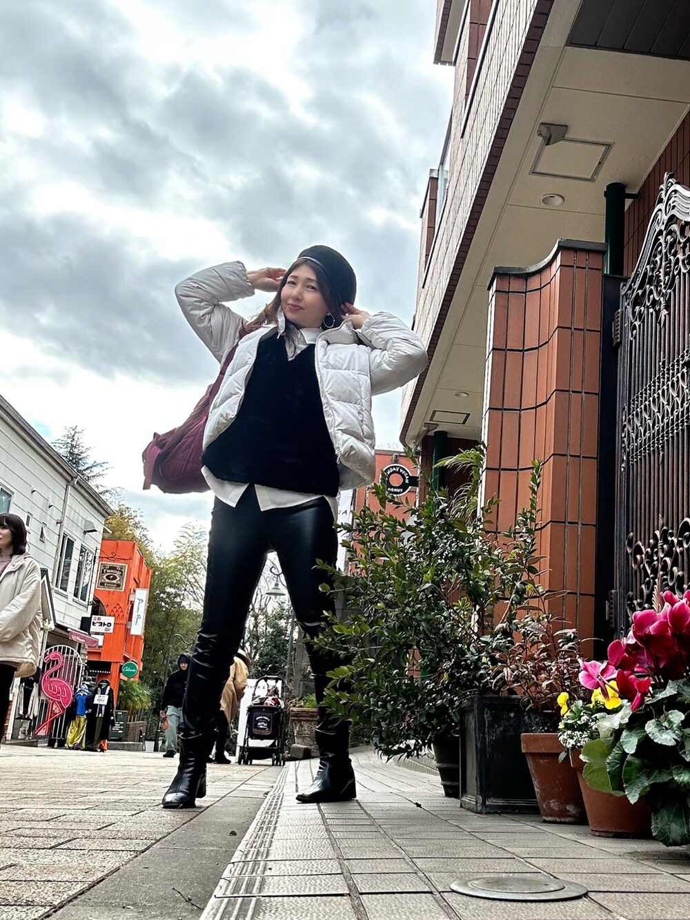 グレー系のダウンジャケット/コート、ブラック系のパンツ、ブラック系のベストを着用したレディースの冬コーディネートの2枚目の写真