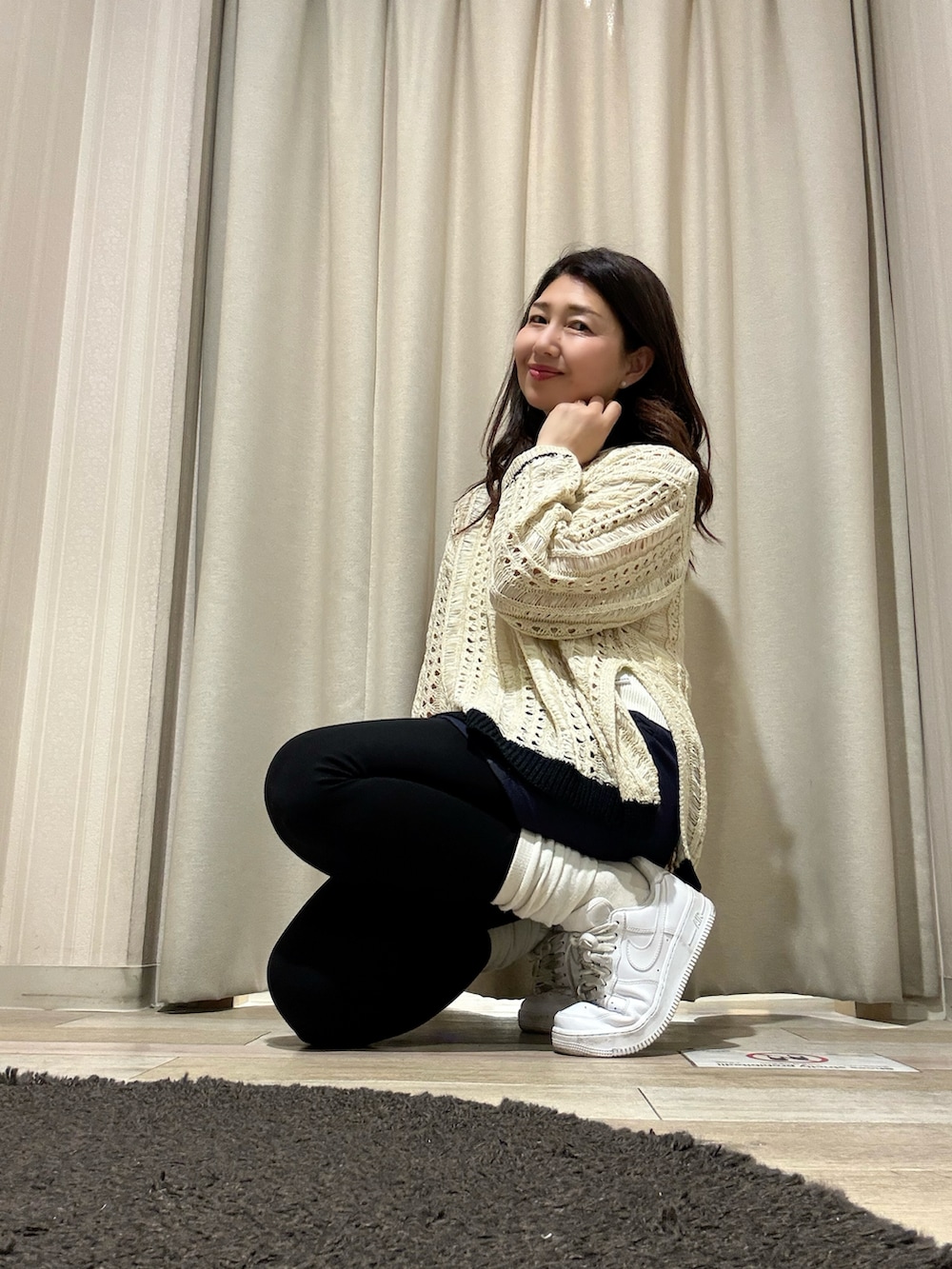 ホワイト系のタンクトップ、レッド系のニット/セーター、ブルー系のデニムパンツを着用したレディースの春コーディネートの4枚目の写真