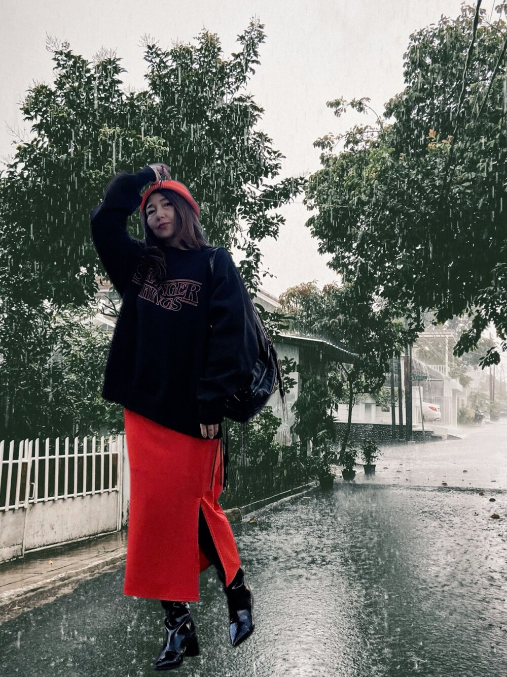 ブラック系のショルダーバッグ、ブラック系のスウェット、オレンジ系のスカートを着用したレディースの冬コーディネートの3枚目の写真