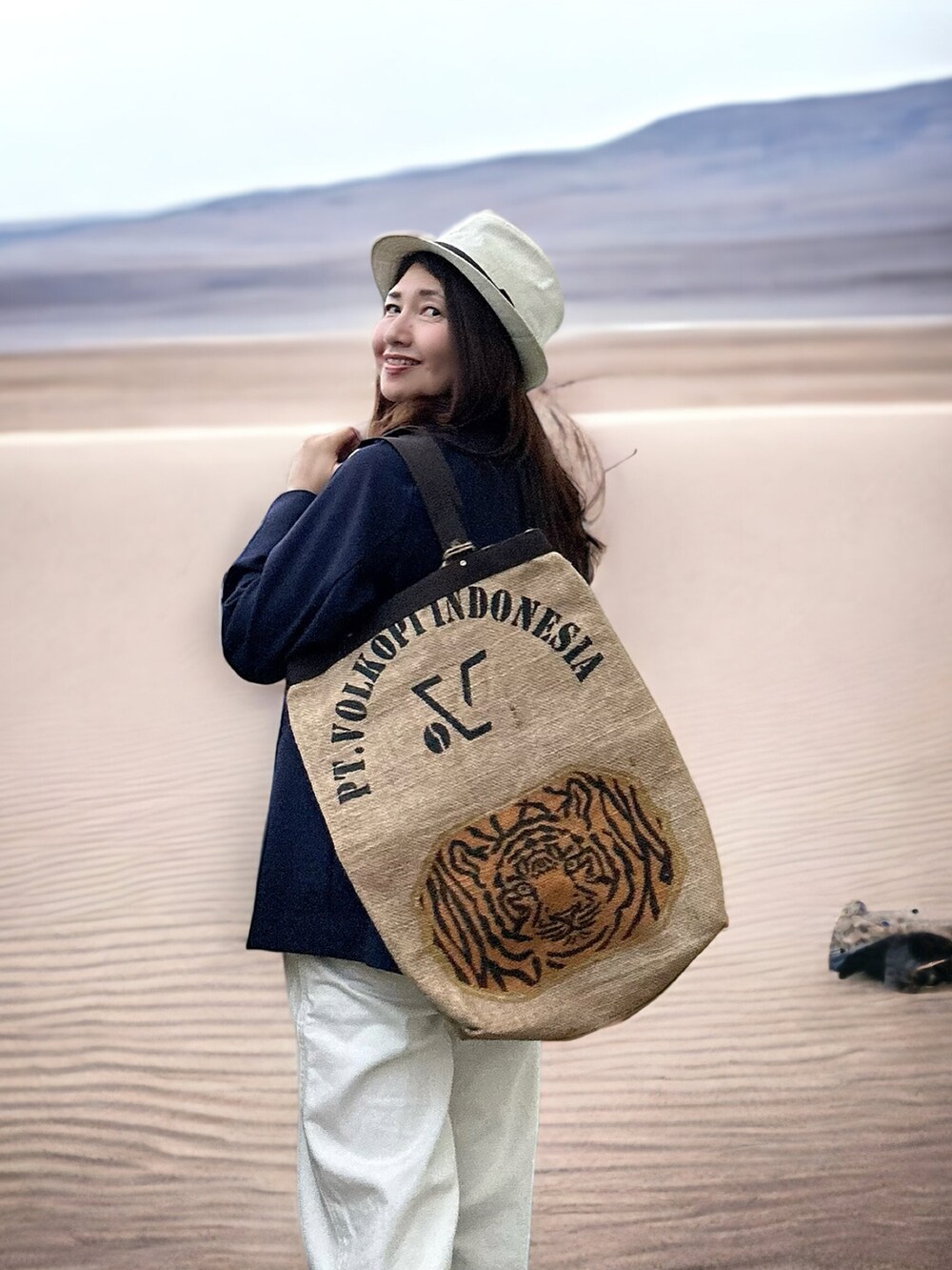 ブルー系のテーラードジャケット、ベージュ系のトートバッグ、ホワイト系のデニムパンツを着用したレディースの秋コーディネートの3枚目の写真