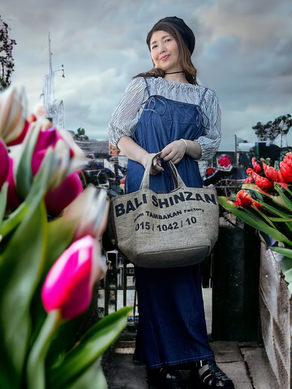 ベージュ系のトートバッグ、ブルー系のサロペット/オーバーオール、ブラック系のシャツ/ブラウスを着用したレディースの秋コーディネートの2枚目の写真