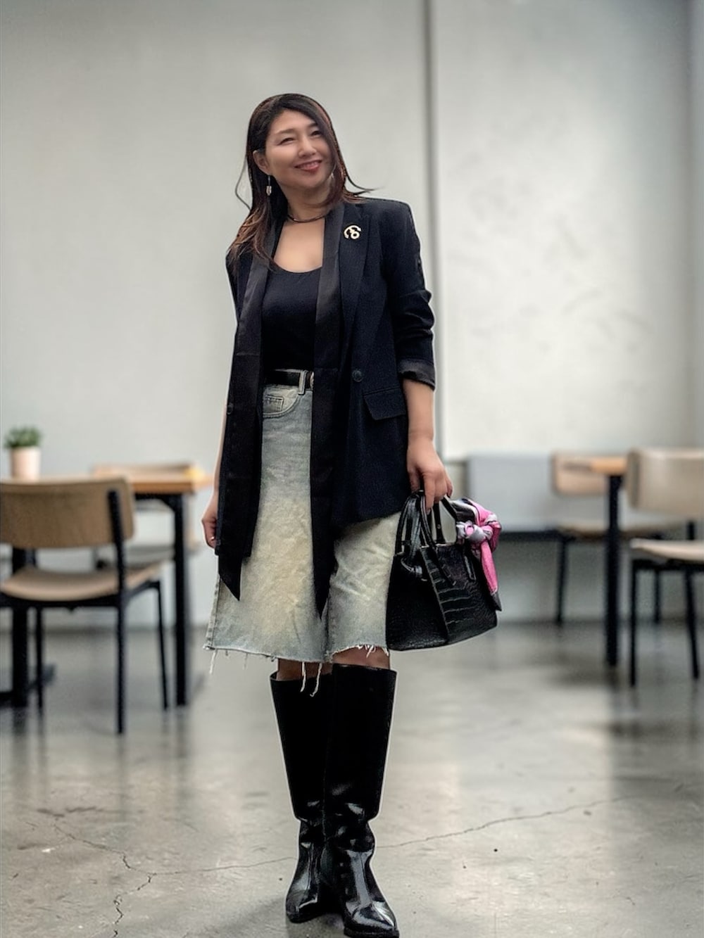 ブラック系のバッグ、ブラック系のブーツ、ブラック系のジャケット/アウターを着用したレディースの春コーディネートの3枚目の写真