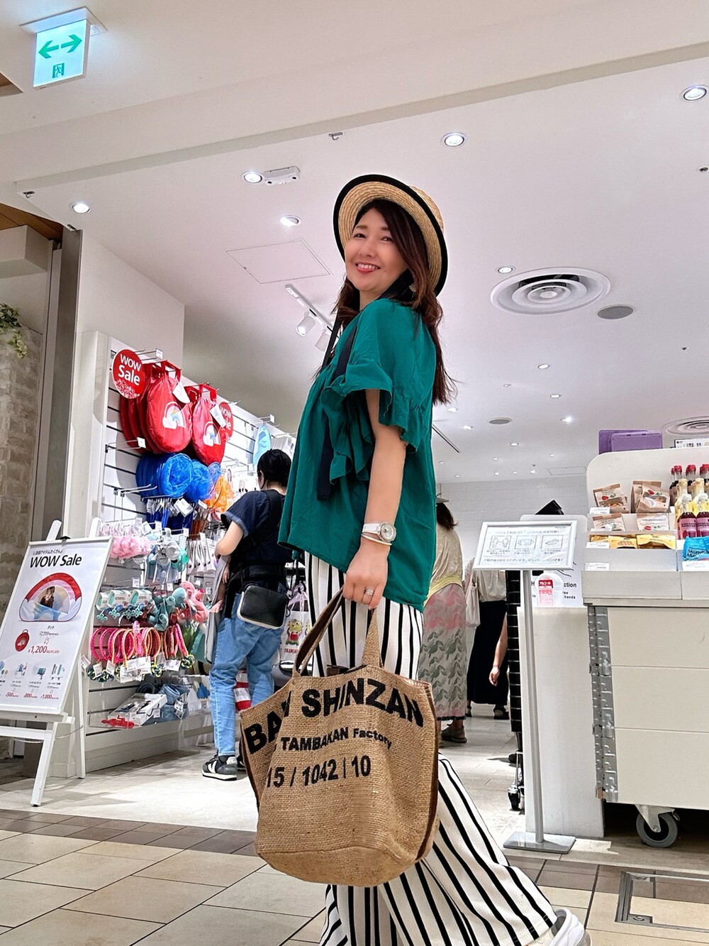 グリーン系のシャツ/ブラウス、ホワイト系のその他パンツ、ベージュ系のトートバッグを着用したレディースの夏コーディネートの3枚目の写真