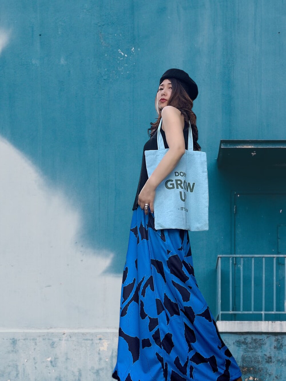 ブルー系のワンピース/ドレス、ブルー系のトートバッグ、ブラック系のハンチング/ベレー帽を着用したレディースの春コーディネートの3枚目の写真