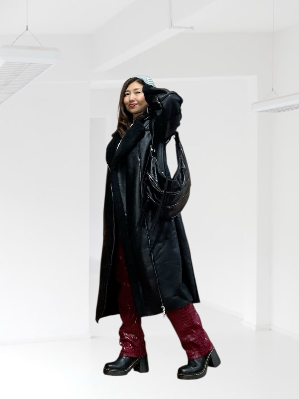 ブラック系のムートンコート、ブラック系のショルダーバッグ、ブラック系のブーツを着用したレディースの秋コーディネートの2枚目の写真