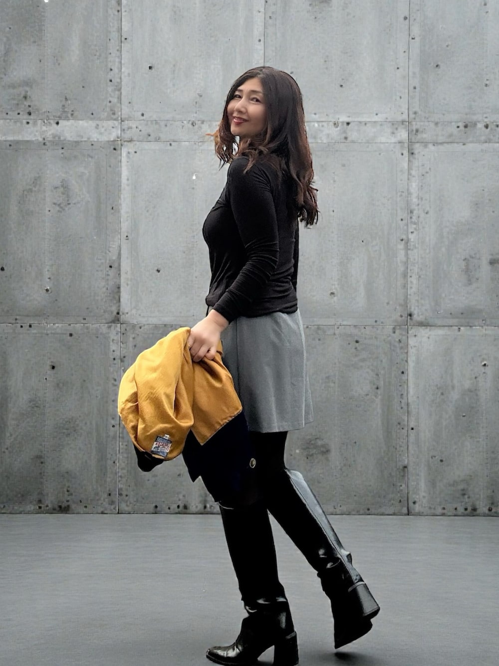 ブルー系のブルゾン、グレー系のパンツ、ブラック系のブーツを着用したレディースの冬コーディネートの4枚目の写真